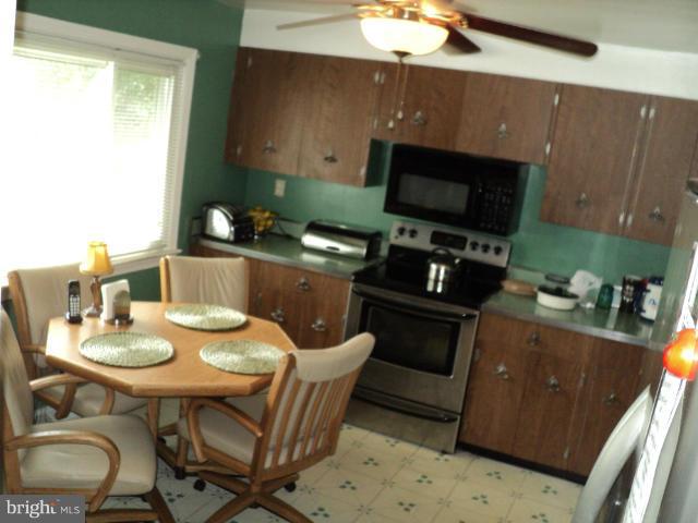 6702 Springbrook Lane Clinton, MD 20735 - Photo 21 of 30 a kitchen with a table chairs and a stove