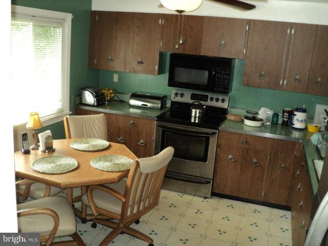 6702 Springbrook Lane Clinton, MD 20735 - Photo 22 of 30 a kitchen with stainless steel appliances kitchen island granite countertop a sink a stove a dining table and chairs