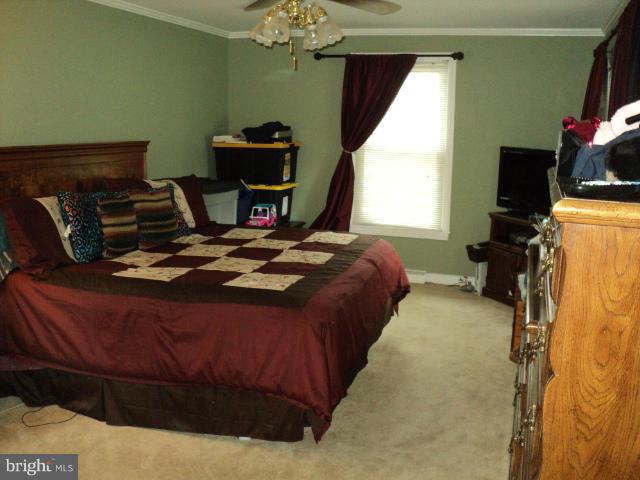 6702 Springbrook Lane Clinton, MD 20735 - Photo 5 of 30 a bed sitting in a bedroom next to a window