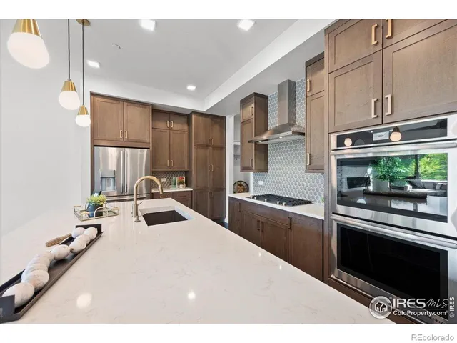 a kitchen with kitchen island granite countertop a sink stainless steel appliances and cabinets