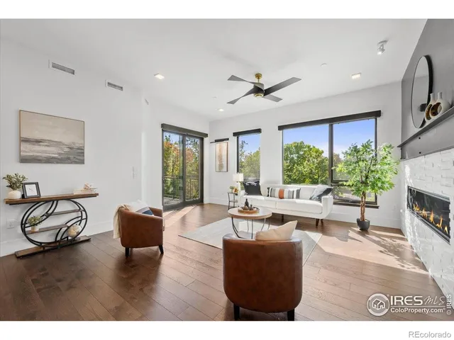 a living room with furniture a fireplace and a large window