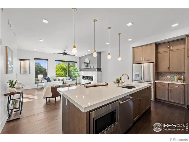 a kitchen with a stove a refrigerator a sink dishwasher with a dining table and chairs with wooden floor