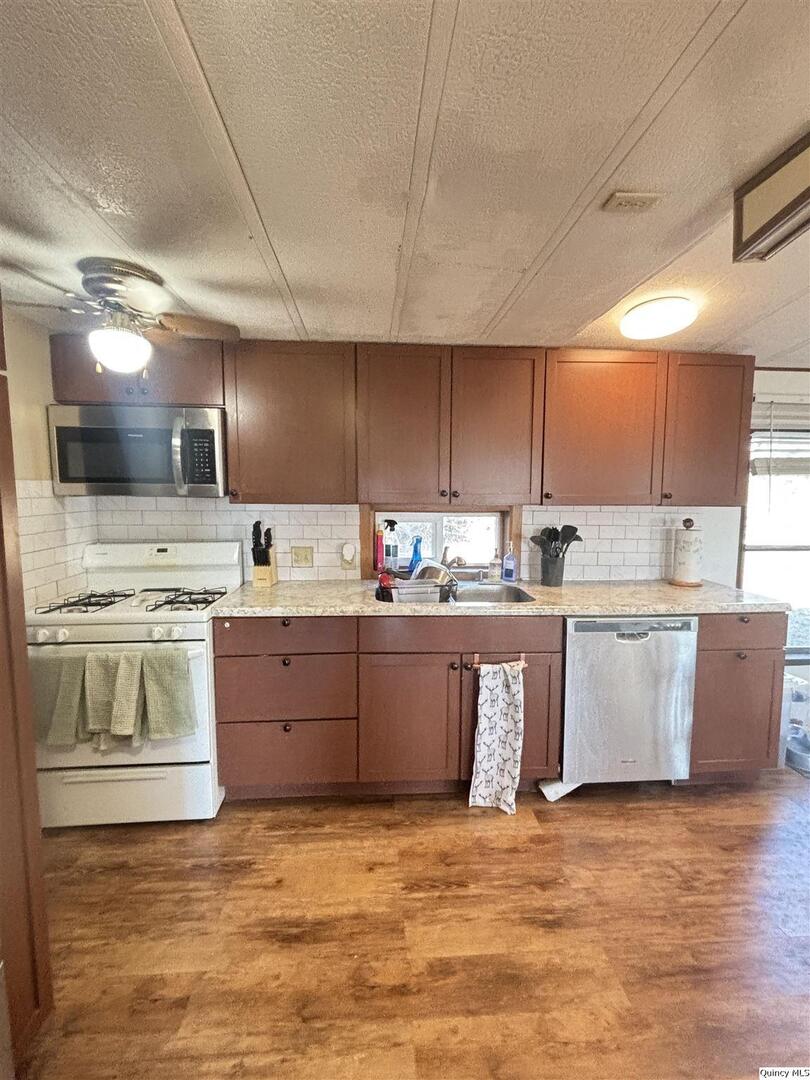 2330 East Co Road 1400 Carthage, IL 62321 - Photo 6 of 19 a kitchen with stainless steel appliances granite countertop a sink a stove and a refrigerator