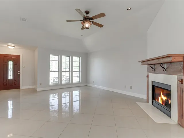a view of an empty room with a fireplace and a window