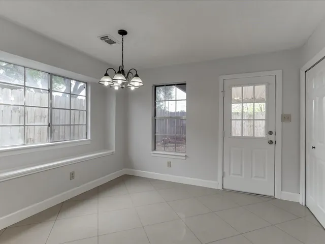 a view of a room with large windows and chandelier