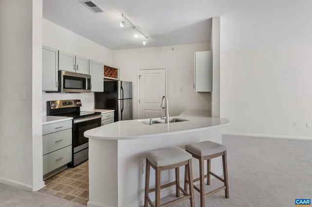a kitchen with kitchen island a sink and appliances