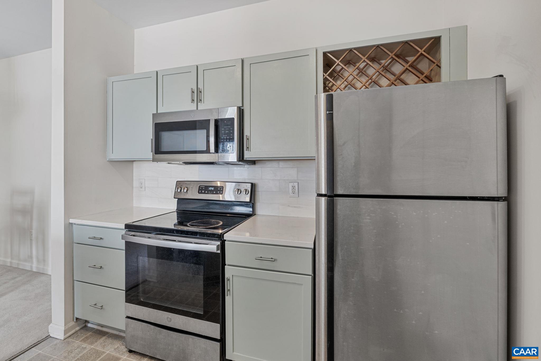 750 Walker Square, Unit 3B Charlottesville, VA 22903 - Photo 9 of 36 a kitchen with refrigerator a microwave and cabinets
