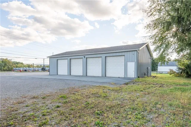 a view of house with backyard and trees in the background