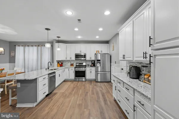 a kitchen with white cabinets and white appliances