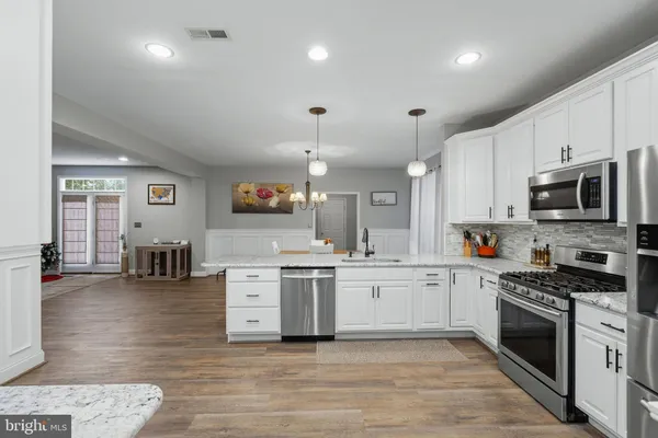 a large kitchen with stainless steel appliances granite countertop a stove and a sink