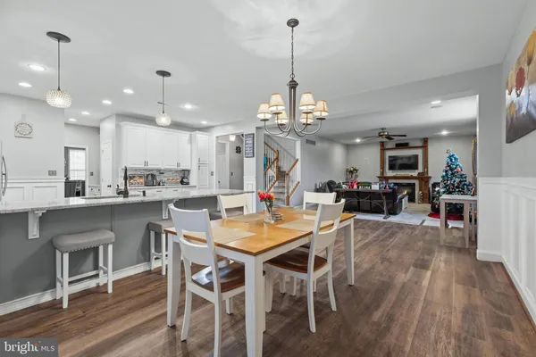 a view of a dining room and livingroom with furniture wooden floor a chandelier