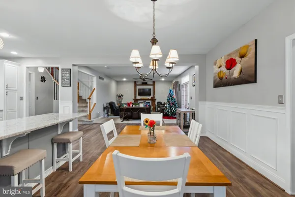 a dining room with wooden floor and chandelier