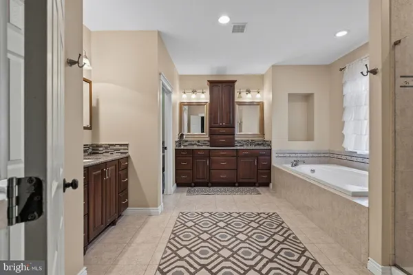 a view of a bathroom with sink mirror and glass door
