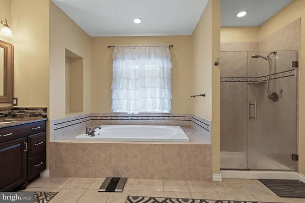 a bathroom with a tub a sink and shower