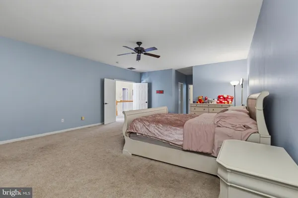 a spacious bedroom with a bed and a chandelier