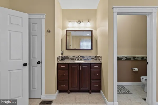 a view of bathroom with a sink cabinet and mirror