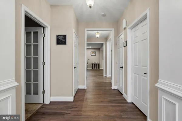 a view of a hallway with wooden floor and closet
