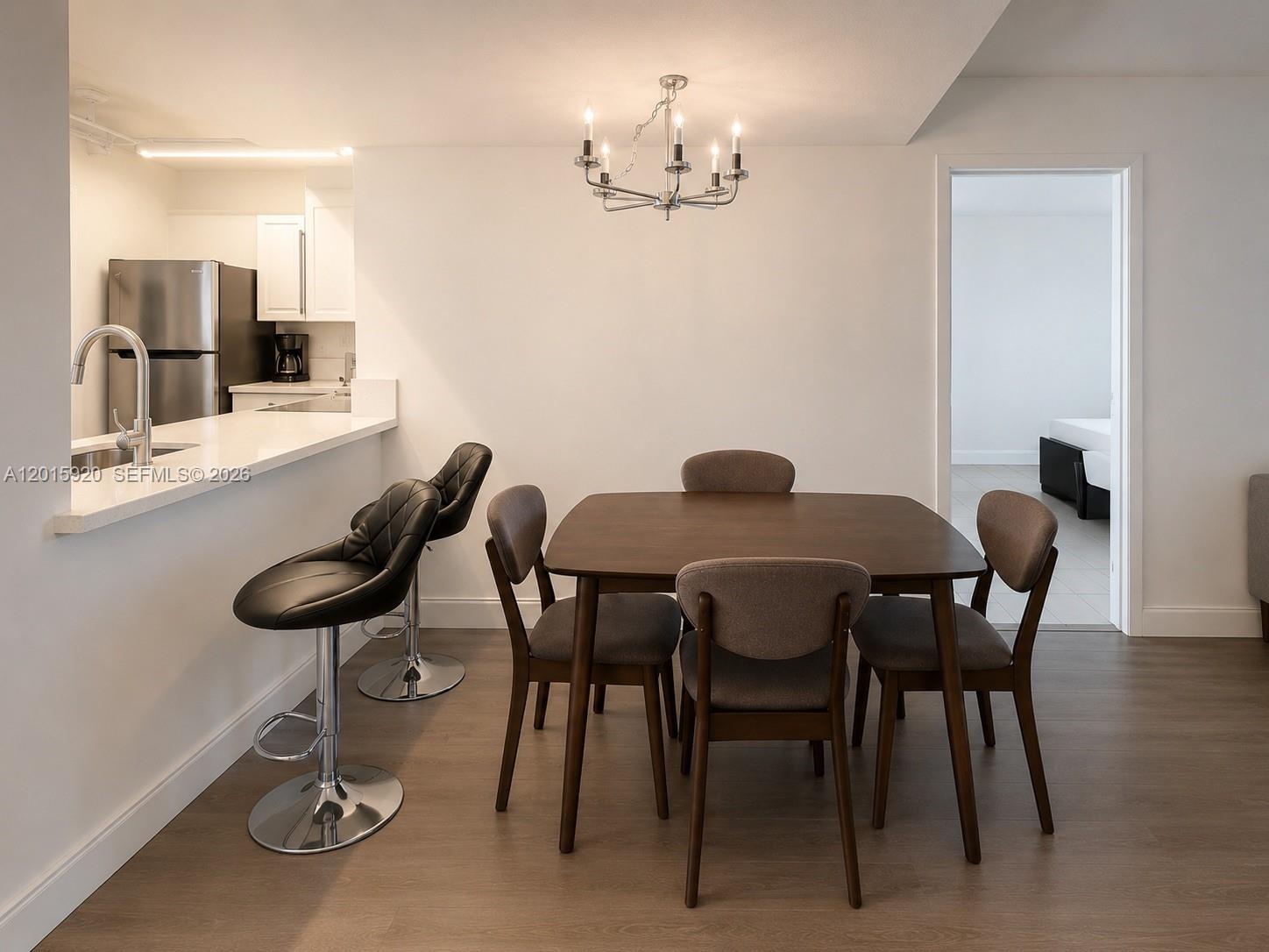14170 Southwest 84th Street, Unit 404F Miami, FL 33183 - Photo 3 of 18 a view of a dining room with furniture and wooden floor