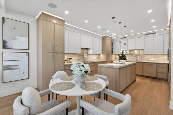 a kitchen that has a sink a table and chairs in it