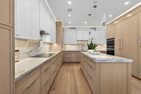 a large kitchen with stainless steel appliances kitchen island granite countertop a large counter top a stove a sink and a refrigerator