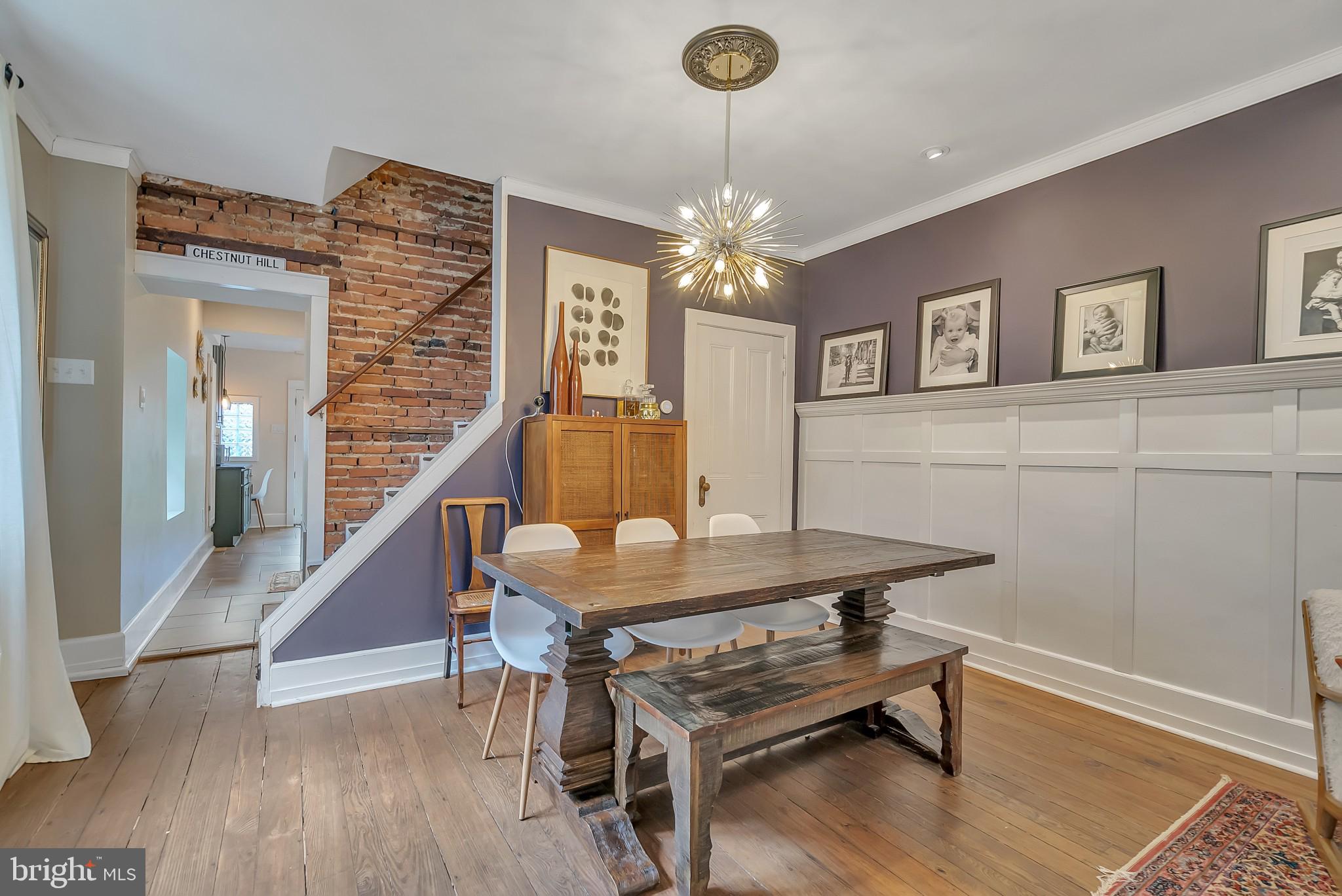 229 Benezet Street Philadelphia, PA 19118 - Photo 11 of 36 a dining room with wooden floor a chandelier a wooden table and chairs