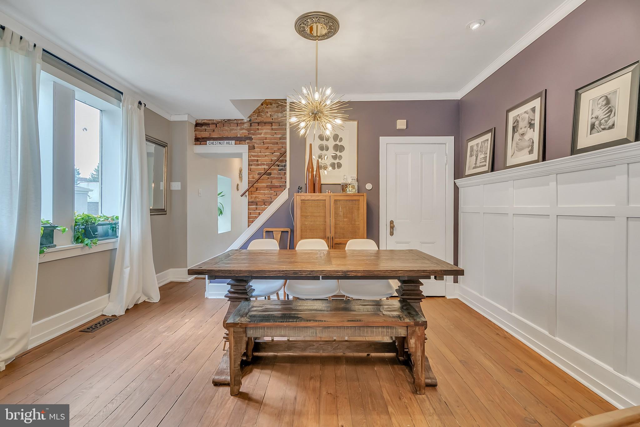 229 Benezet Street Philadelphia, PA 19118 - Photo 10 of 36 a living room with furniture a table and a chandelier