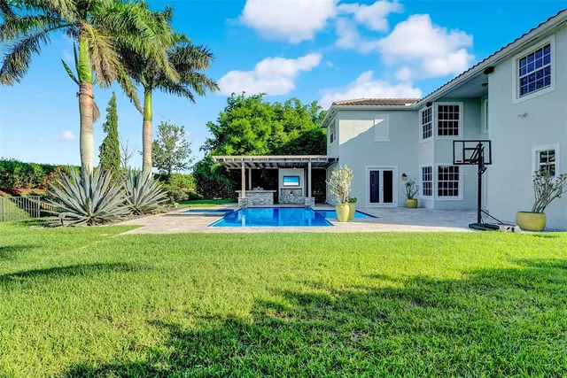 an aerial view of residential houses with outdoor space and swimming pool