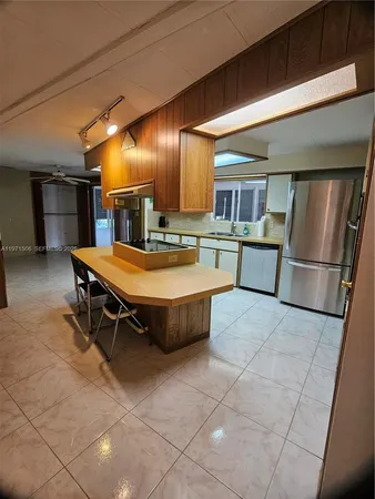 a kitchen with stainless steel appliances granite countertop a sink and a refrigerator