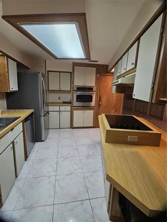 a kitchen with a sink a stove top oven and cabinets