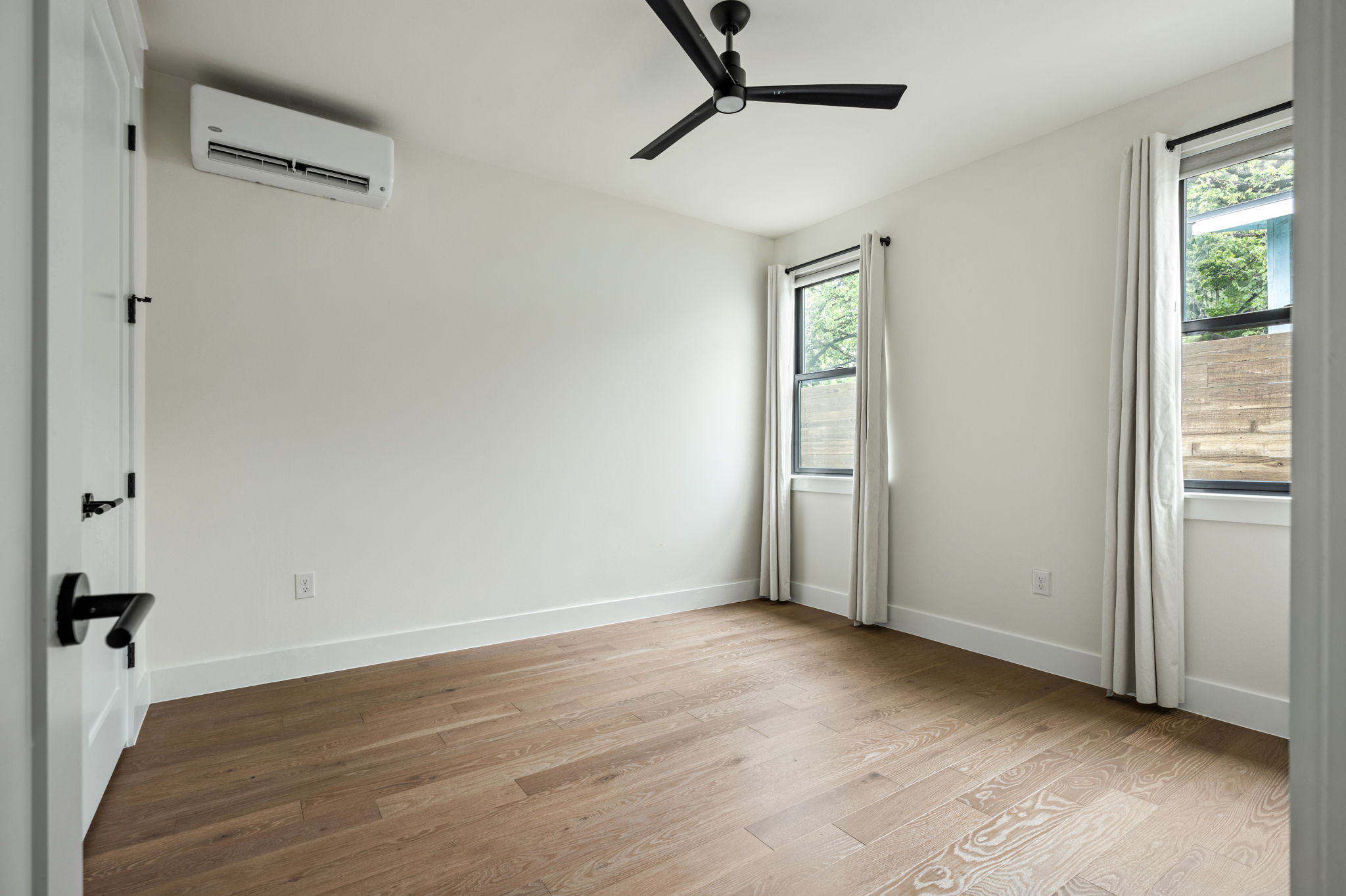 3508 Lyons Road Austin, TX 78702 - Photo 20 of 40 Hardwood floors and generous natural light create an inviting atmosphere in this well-appointed bedroom.