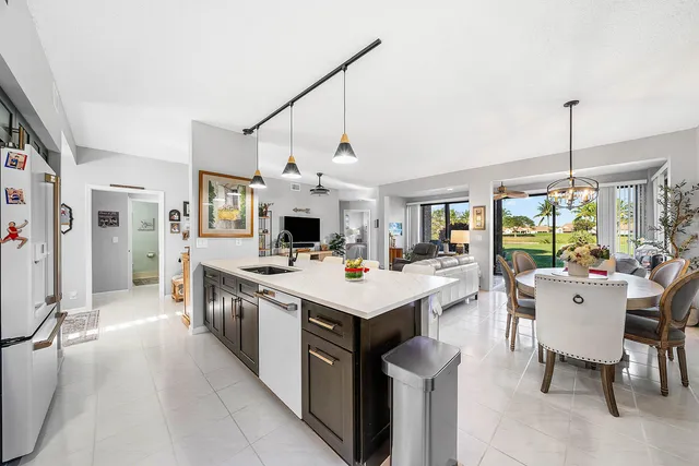 a kitchen that has a lot of white cabinets and stainless steel appliances