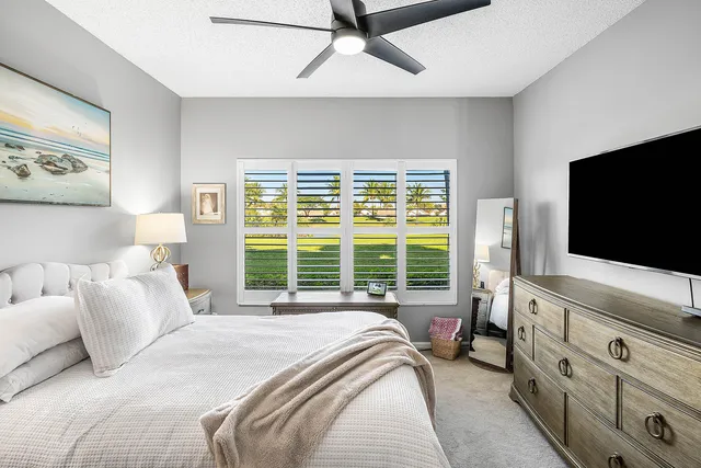 a bedroom with a bed and a flat tv screen on dresser