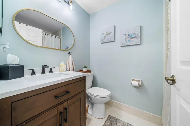 a bathroom with a toilet a sink and mirror