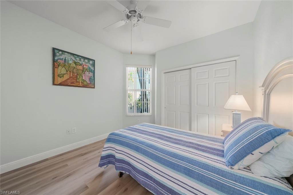 4630 Winged Foot Court, Unit 101 Naples, FL 34112 - Photo 11 of 43 a bedroom with a bed and a chandelier