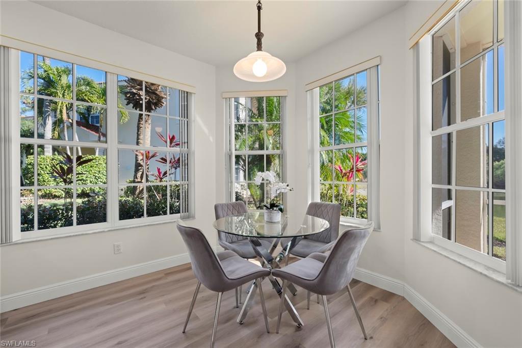 4630 Winged Foot Court, Unit 101 Naples, FL 34112 - Photo 18 of 43 a dining room with furniture window outside view and wooden floor