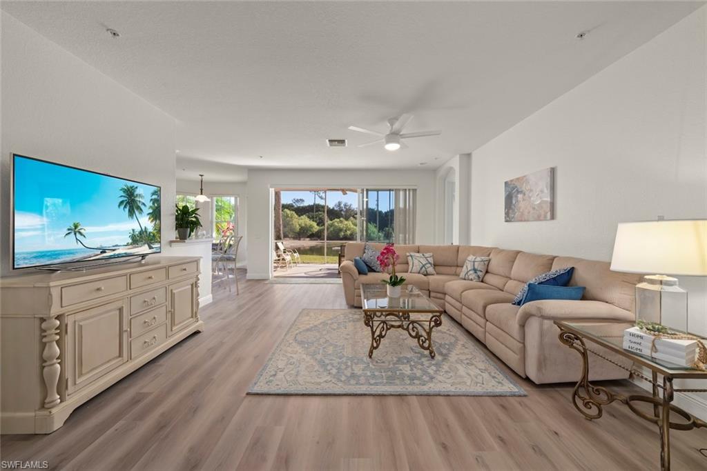 4630 Winged Foot Court, Unit 101 Naples, FL 34112 - Photo 5 of 43 a living room with furniture and a flat screen tv
