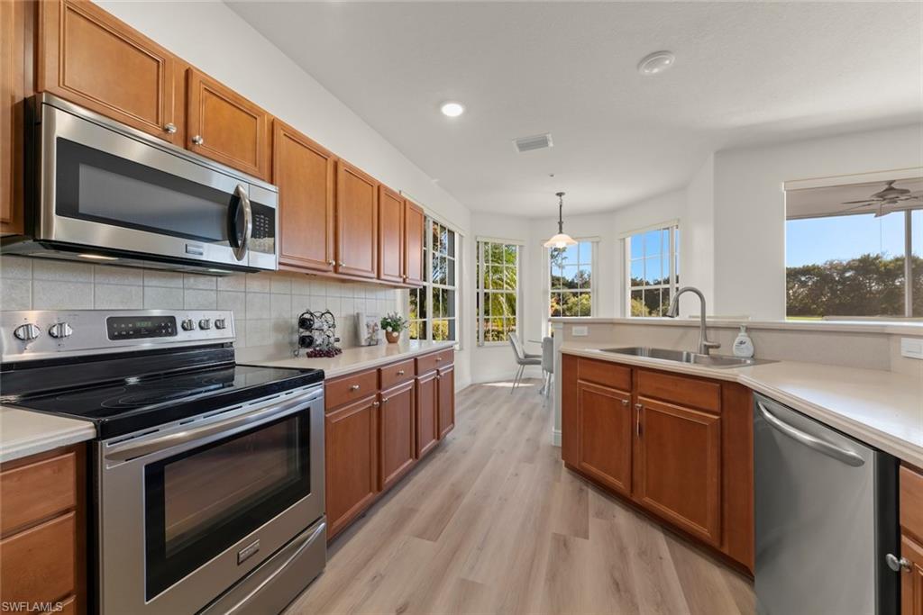4630 Winged Foot Court, Unit 101 Naples, FL 34112 - Photo 6 of 43 a kitchen with stainless steel appliances a stove microwave and cabinets