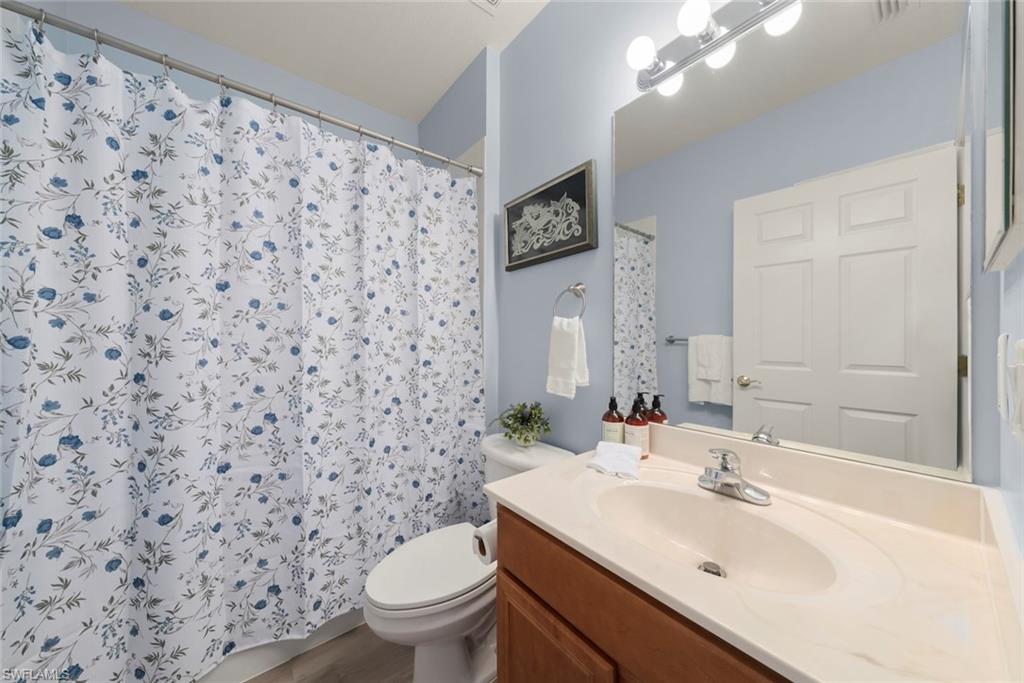 4630 Winged Foot Court, Unit 101 Naples, FL 34112 - Photo 10 of 43 a bathroom with a sink toilet and mirror