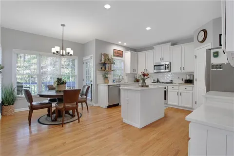 a kitchen with kitchen island stainless steel appliances a dining table and chairs