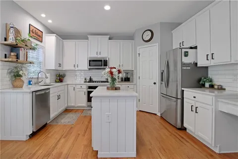 a kitchen with white cabinets and white appliances