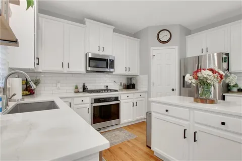 a kitchen with granite countertop white cabinets and white appliances
