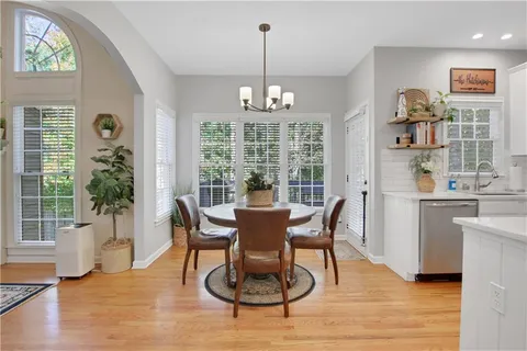a dining room with furniture a chandelier and wooden floor