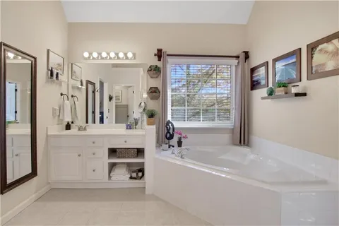 a spacious bathroom with double vanity and a mirror