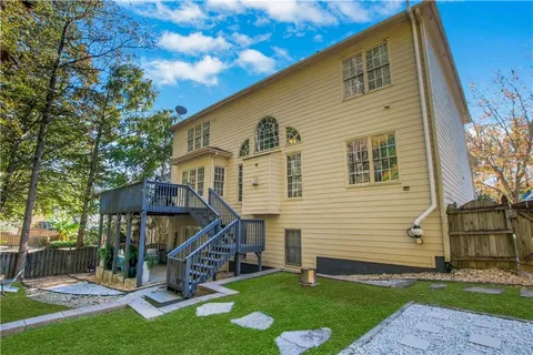a view of an wooden deck and a yard with wooden fence