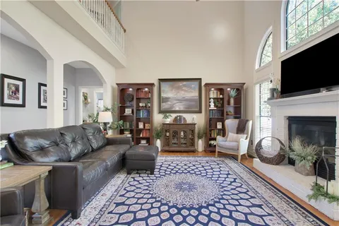 a living room with furniture a flat screen tv and a fireplace
