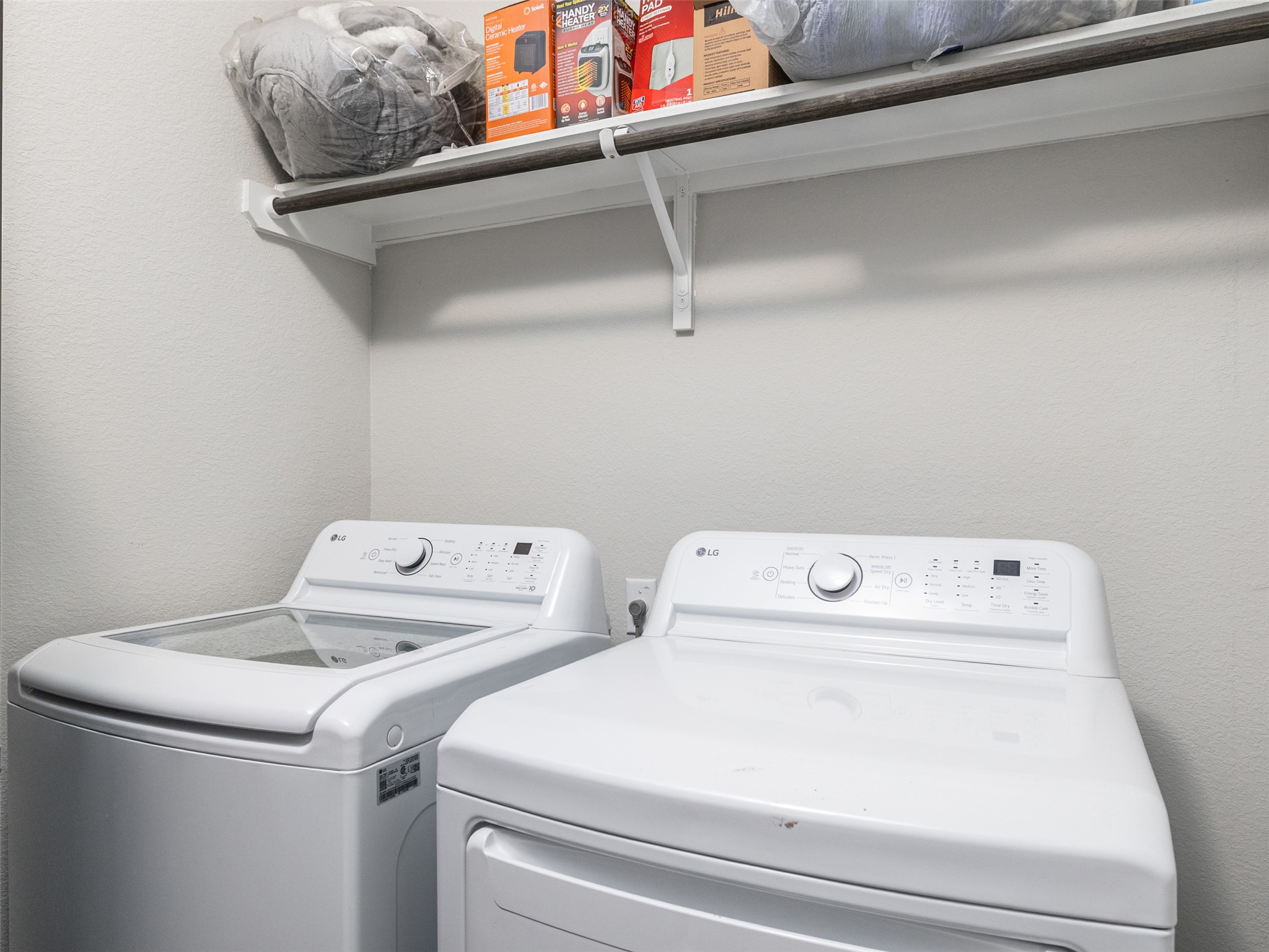 121 Graver Street Georgetown, TX 78626 - Photo 11 of 28 Functional laundry room offers convenience with a washer, dryer, and an overhead shelf for storage.