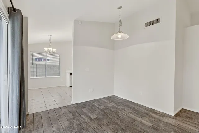 an empty room with wooden floor and mirror