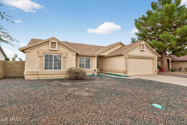 a front view of a house with a garden and yard