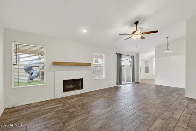a view of an empty room with a fireplace and a window