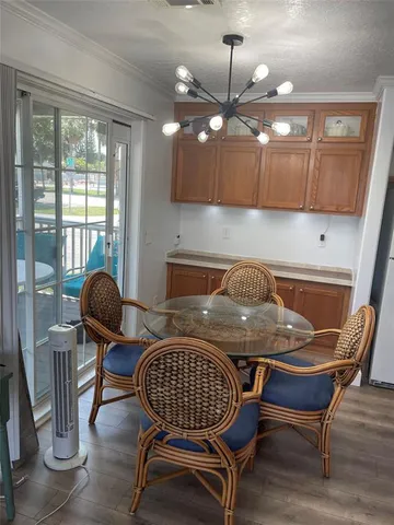 a kitchen with granite countertop a dining table chairs and a glass door